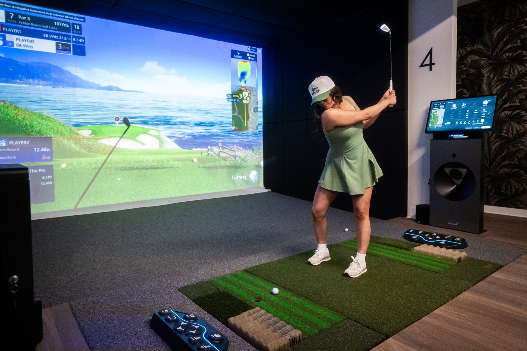 Golf Envy member mid-swing on a simulator bay